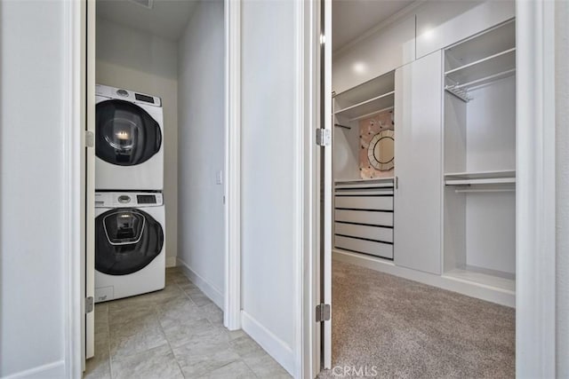 laundry area featuring laundry area, light colored carpet, and stacked washer and clothes dryer