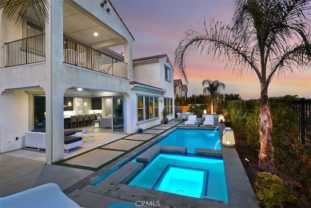 view of swimming pool featuring a pool with connected hot tub, a patio area, fence, and an outdoor living space