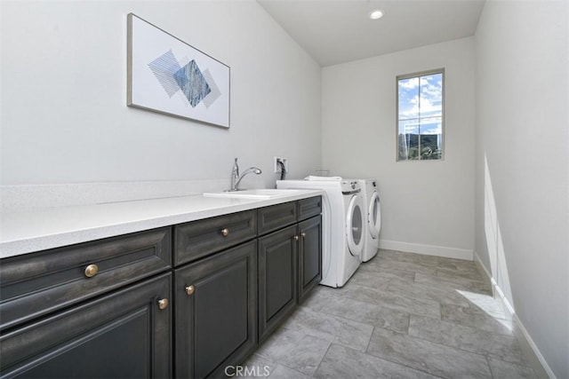 laundry area featuring washing machine and clothes dryer, recessed lighting, cabinet space, a sink, and baseboards