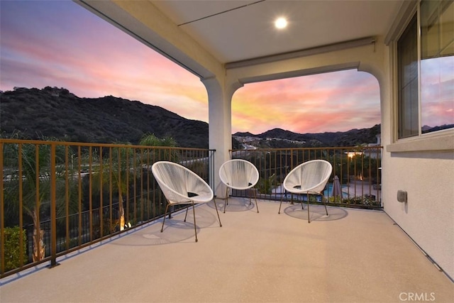 view of patio with a balcony and a mountain view