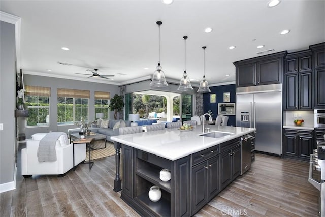 kitchen with stainless steel appliances, light countertops, a sink, and ornamental molding