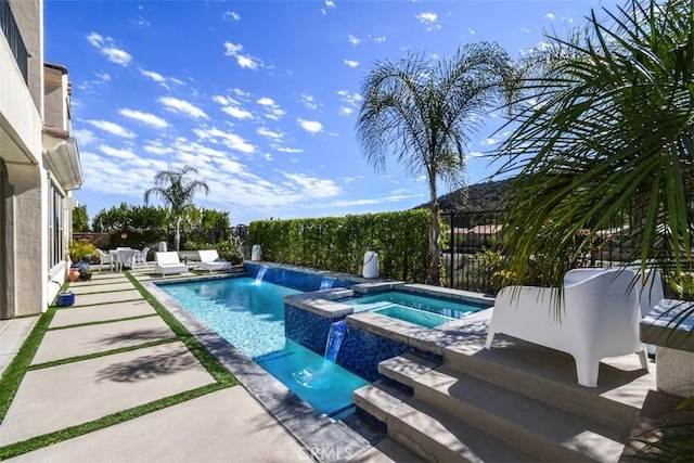 view of swimming pool featuring a patio area, a fenced backyard, and a pool with connected hot tub