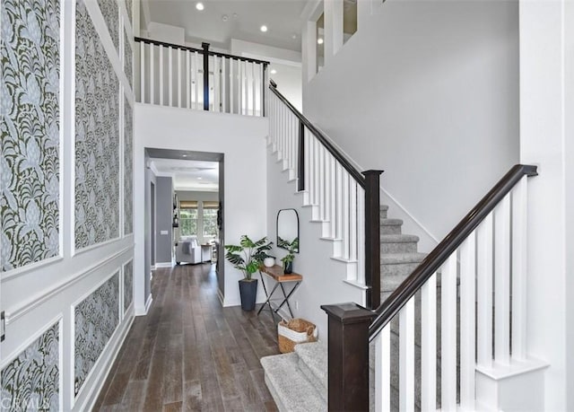 entryway with stairway, wood finished floors, a towering ceiling, and recessed lighting