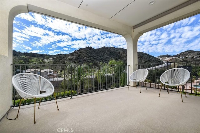 view of patio featuring a balcony and a mountain view