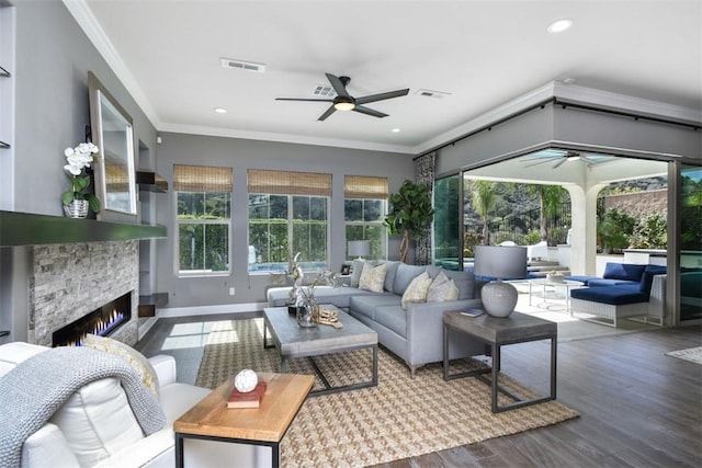 sunroom featuring ceiling fan, a fireplace, and visible vents