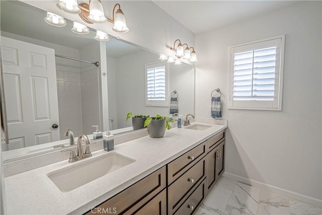 bathroom with double vanity, marble finish floor, baseboards, and a sink