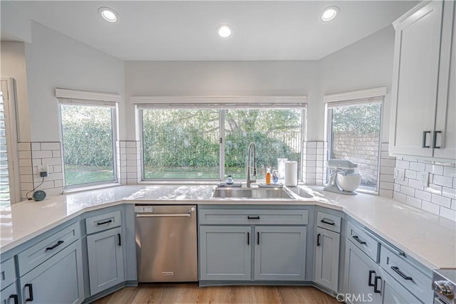 kitchen featuring appliances with stainless steel finishes, light wood-style floors, a healthy amount of sunlight, and a sink