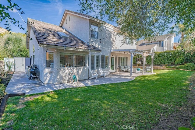 rear view of house with a patio area, a lawn, a pergola, and stucco siding