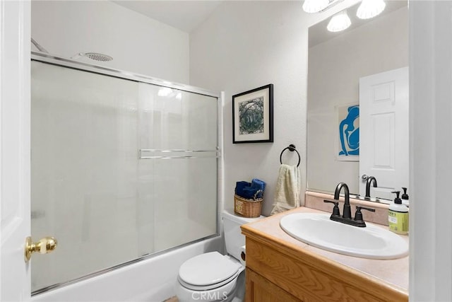 bathroom with vanity, toilet, and bath / shower combo with glass door