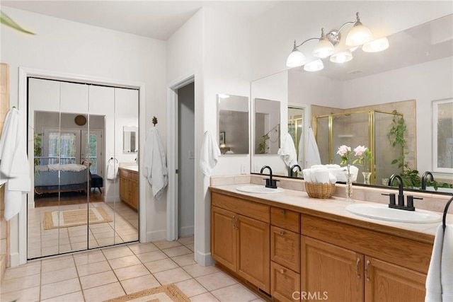 bathroom featuring tile patterned flooring, connected bathroom, a stall shower, and a sink