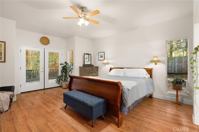 bedroom featuring multiple windows, light wood-style floors, and access to exterior