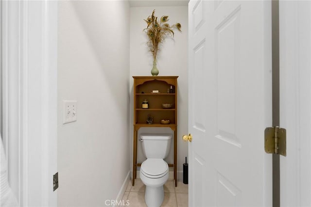 bathroom featuring tile patterned flooring, toilet, and baseboards