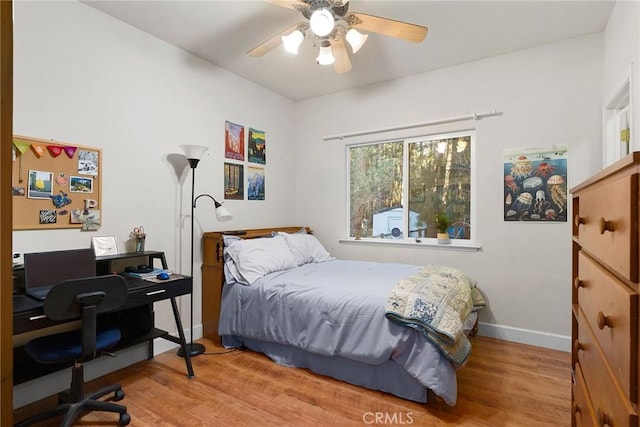 bedroom featuring ceiling fan, baseboards, and wood finished floors