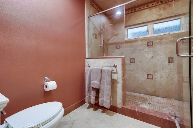 full bath featuring toilet, a shower stall, and baseboards