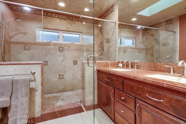 full bathroom with tile patterned flooring, a sink, a shower stall, and double vanity