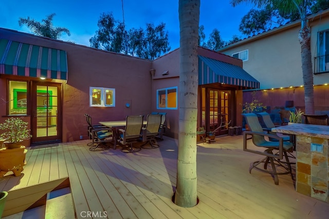 deck with french doors and outdoor dining area