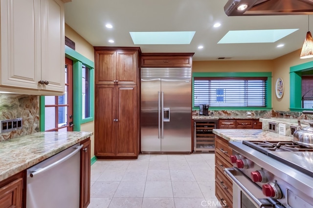 kitchen featuring a skylight, beverage cooler, recessed lighting, and high quality appliances