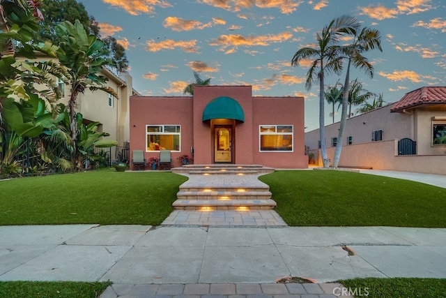 view of front of property featuring a yard and stucco siding