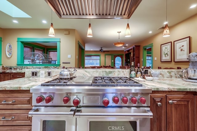 kitchen with range with two ovens, a skylight, open floor plan, and recessed lighting