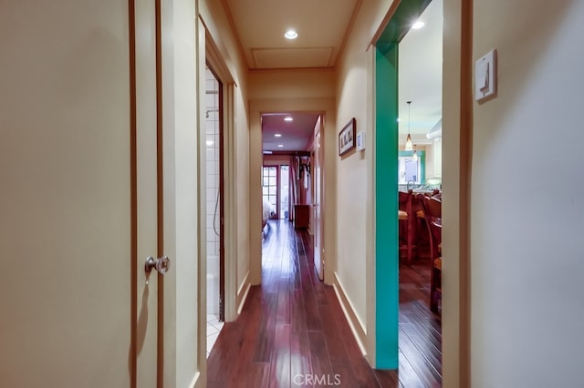 hall featuring attic access, recessed lighting, baseboards, and wood finished floors