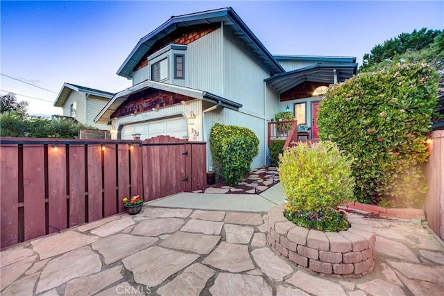 exterior space featuring a garage, concrete driveway, and fence