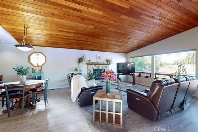 living area featuring vaulted ceiling, a fireplace, wood finished floors, and wooden ceiling