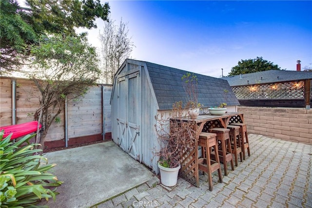 view of shed with a fenced backyard and outdoor dry bar