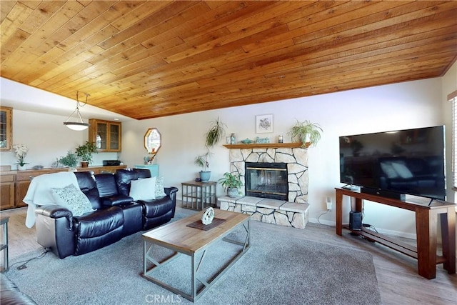 living room with lofted ceiling, wood ceiling, wood finished floors, and a stone fireplace