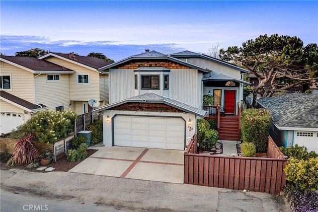 view of front of house featuring concrete driveway, fence, and an attached garage