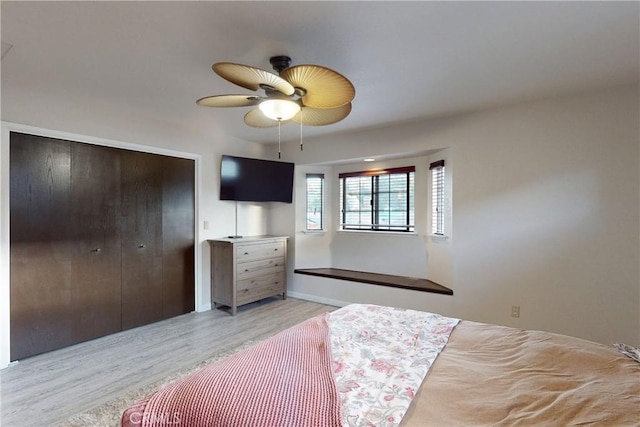 bedroom with a closet, a ceiling fan, and light wood-style floors