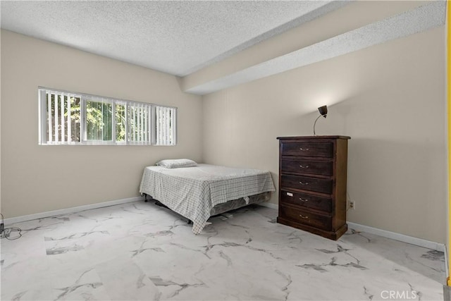 bedroom with marble finish floor, baseboards, and a textured ceiling