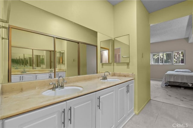 full bathroom featuring double vanity, marble finish floor, ensuite bath, and a sink