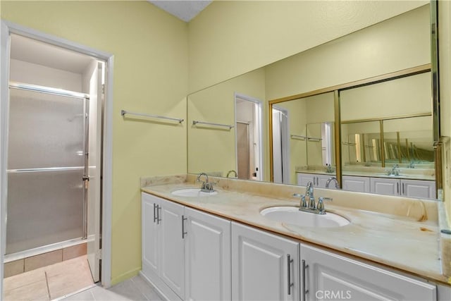 bathroom featuring double vanity, a sink, and tile patterned floors