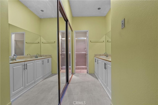 bathroom with tile patterned floors, a closet, and vanity