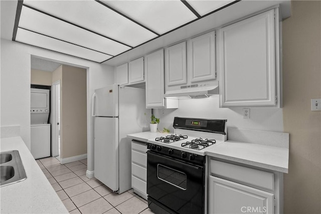 kitchen featuring stacked washer and dryer, gas range oven, white cabinets, and under cabinet range hood