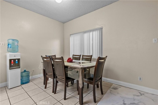 dining space with a textured ceiling and baseboards