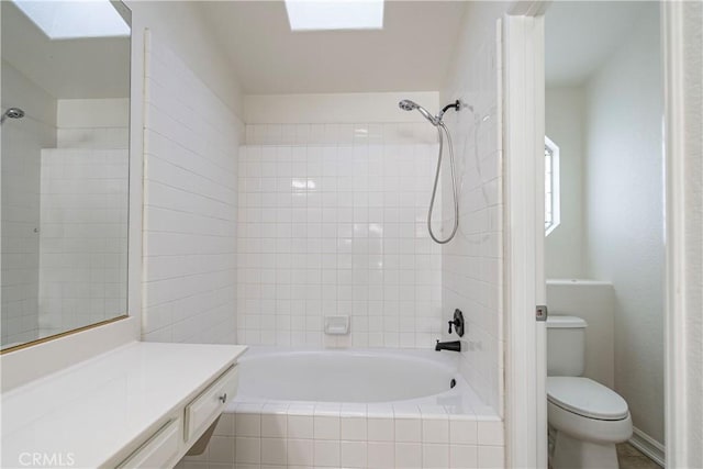 full bath with toilet, a skylight, and tiled shower / bath combo