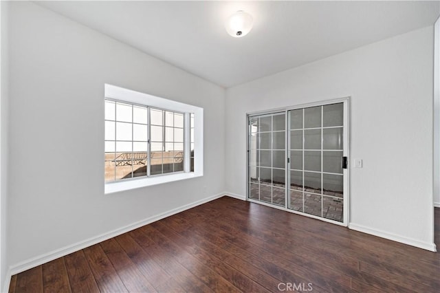 unfurnished room with baseboards and hardwood / wood-style floors