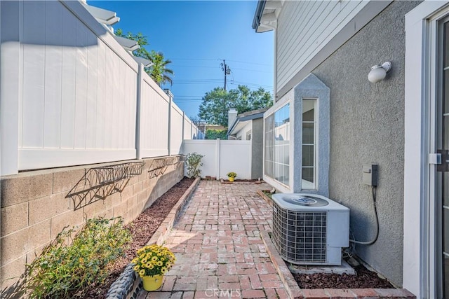 view of patio with a fenced backyard and central air condition unit