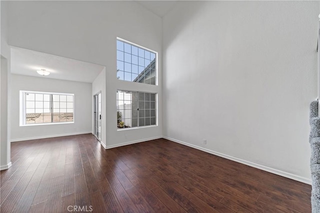 foyer featuring a high ceiling, dark wood finished floors, and baseboards