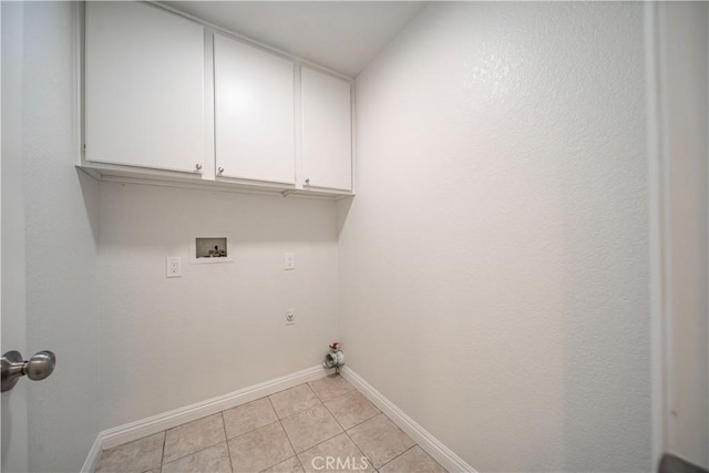 laundry area with light tile patterned floors, gas dryer hookup, hookup for a washing machine, baseboards, and cabinet space