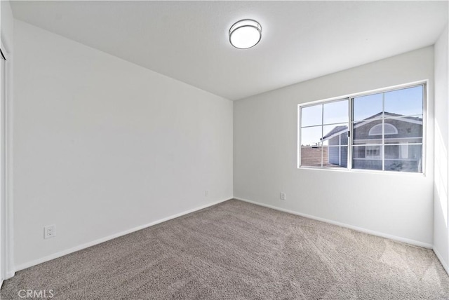 carpeted spare room with baseboards