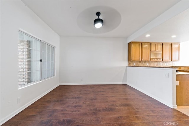 kitchen featuring baseboards, dark wood finished floors, ceiling fan, backsplash, and recessed lighting