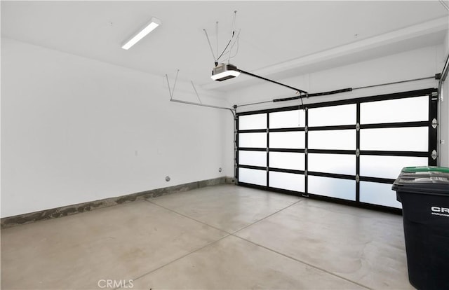 garage with a garage door opener and baseboards