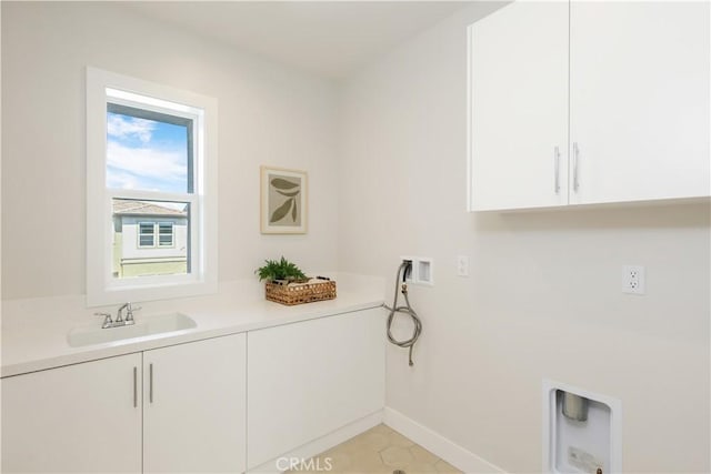 washroom featuring hookup for a washing machine, cabinet space, baseboards, and a sink