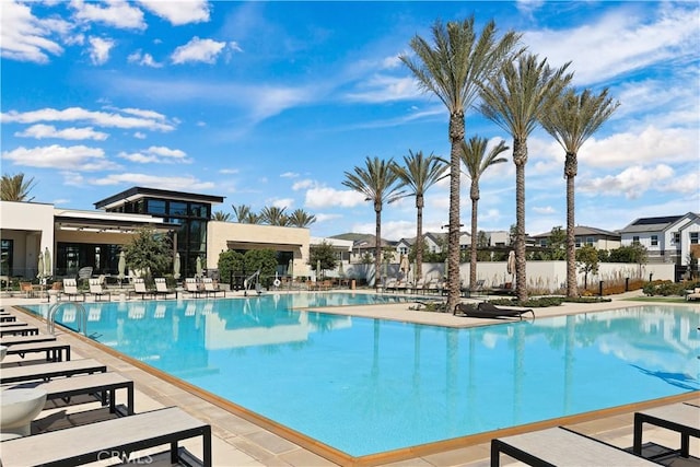 community pool with a patio area and fence