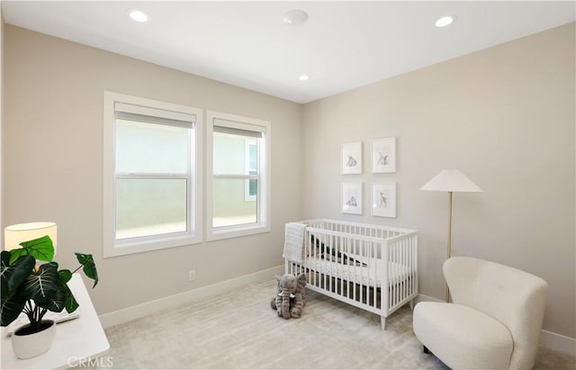 bedroom with recessed lighting, baseboards, a nursery area, and carpet flooring