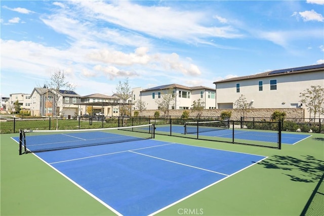 view of sport court with a residential view and fence