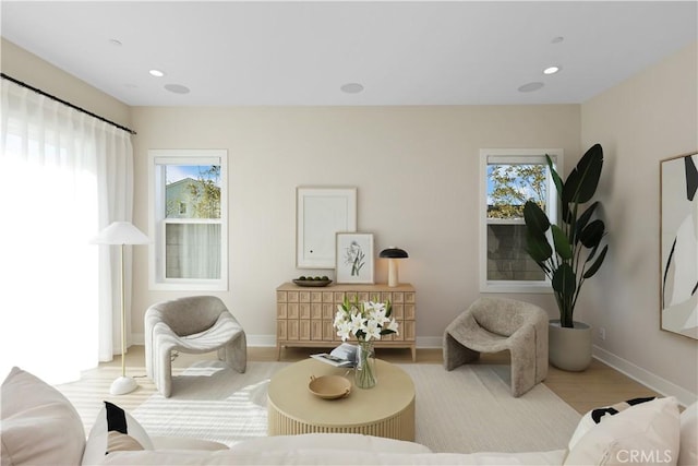 living area with recessed lighting, baseboards, and wood finished floors