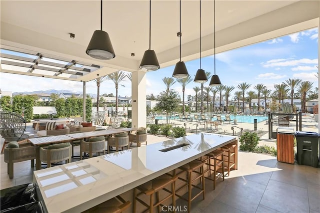 view of patio featuring a community pool, a pergola, and outdoor dry bar